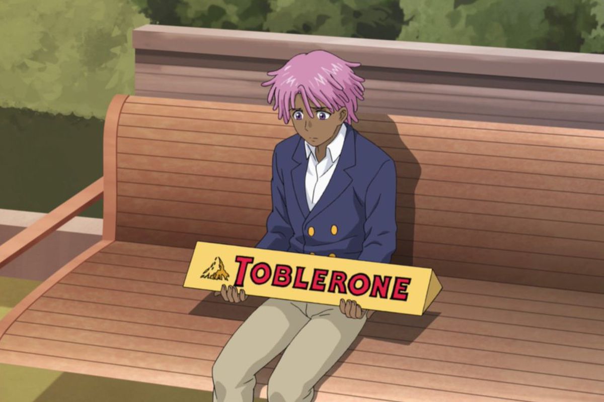 Kaz Kaan sitting on a park bench, holding a big Toblerone