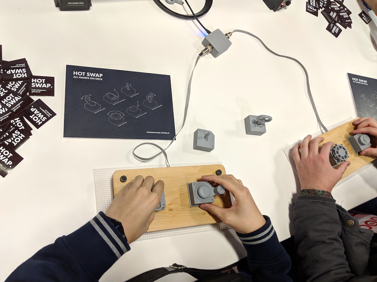 Two people playing Hot Swap, moving around gray button pieces in front