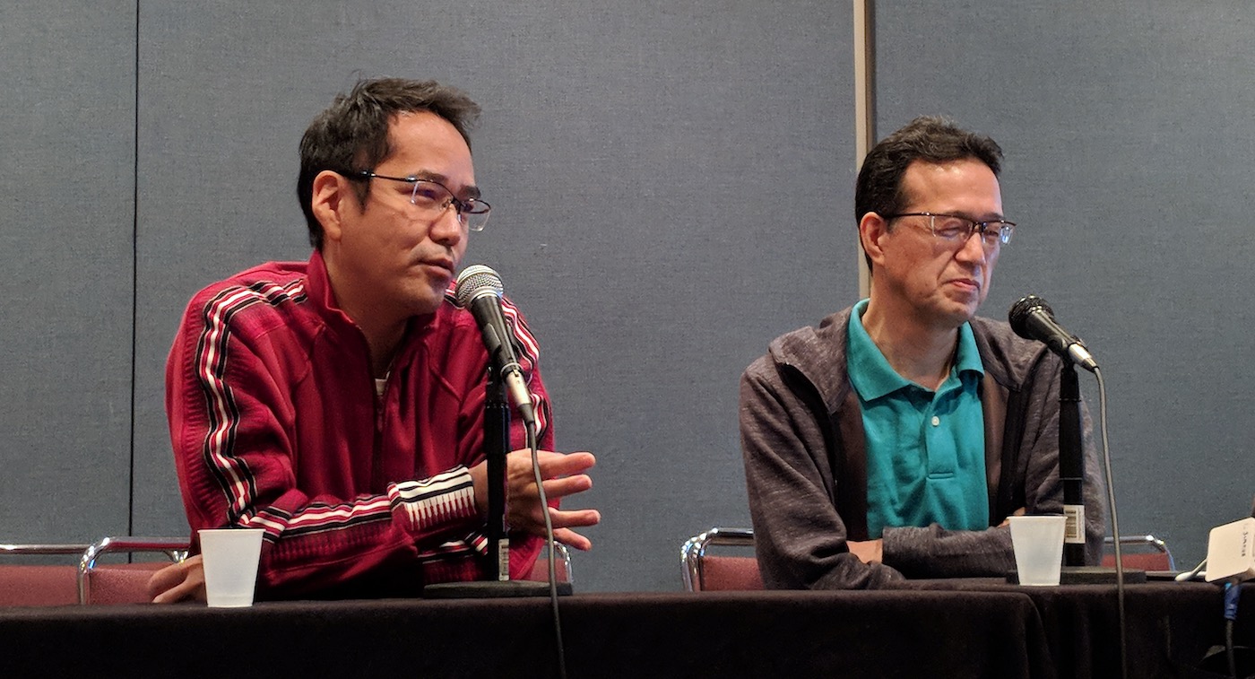 Kenji Kamiyama speaking on a panel with Shinji Aramaki sitting to his left