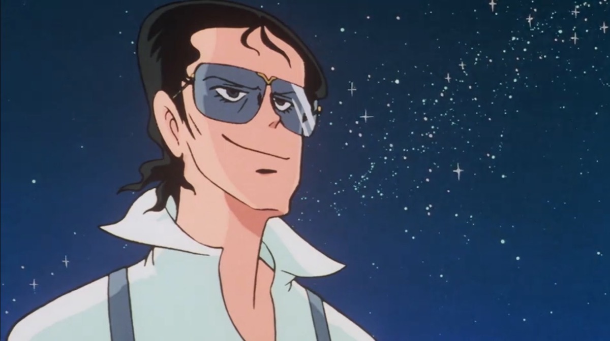 Marciano, a man with wavy hair and sunglasses, smirks and stares at the stars.