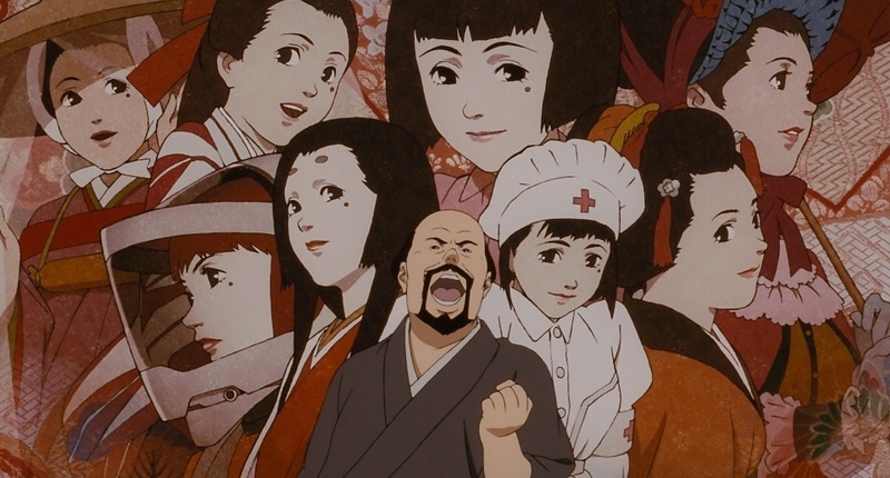 Genya looking excited, standing in front of a collage of all of Chiyoko’s major roles.
