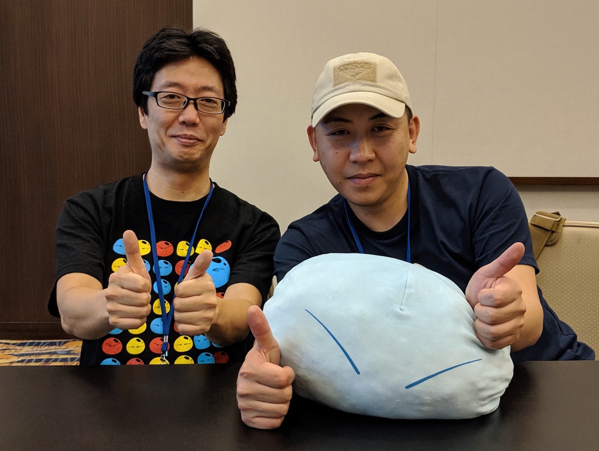 Atsushi Nakayama and Ryouma Ebata smiling and giving a thumbs up while Ebata holds a slime plushie.