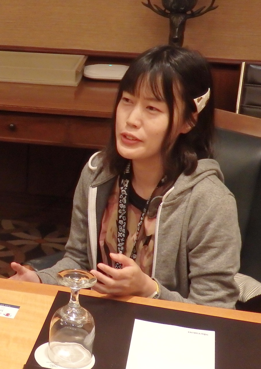 A young Japanese woman sitting at a table talking