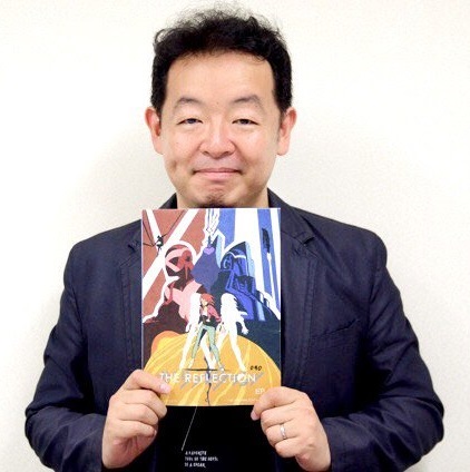 Hiroshi Nagahama holding The Reflection key art via Otakon